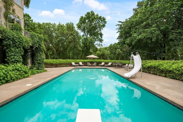 4325 Trillium Ln W, Minnetrista, MN 55364 - view of swimming pool featuring a water slide, a diving board, a patio, and view of scattered trees