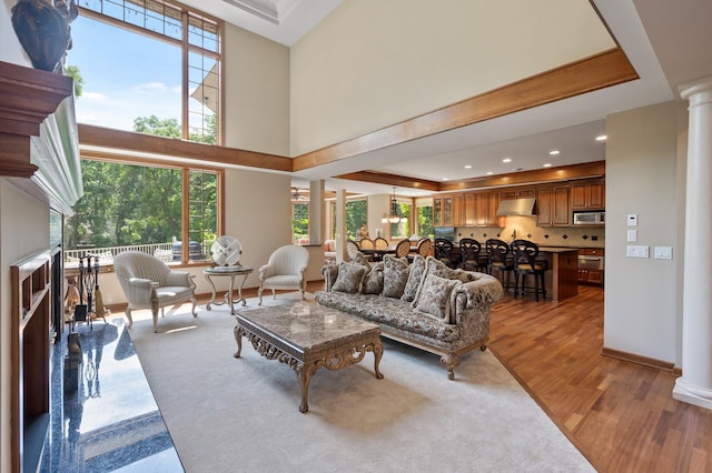 4325 Trillium Ln W, Minnetrista, MN 55364 - living room featuring decorative columns, wood finished floors, healthy amount of natural light, recessed lighting, and a towering ceiling