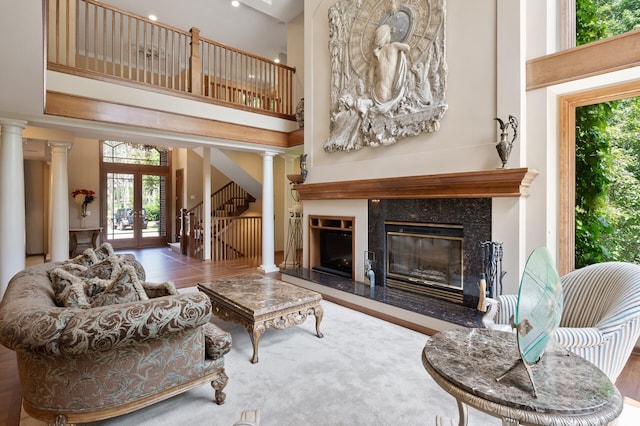4325 Trillium Ln W, Minnetrista, MN 55364 - living room featuring ornate columns, a high ceiling, plenty of natural light, and a premium fireplace