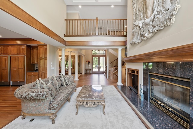 4325 Trillium Ln W, Minnetrista, MN 55364 - living area featuring decorative columns, a high ceiling, a premium fireplace, wood finished floors, and recessed lighting