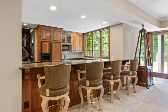 4325 Trillium Ln W, Minnetrista, MN 55364 - kitchen with paneled built in fridge, brown cabinets, black microwave, recessed lighting, and a kitchen breakfast bar