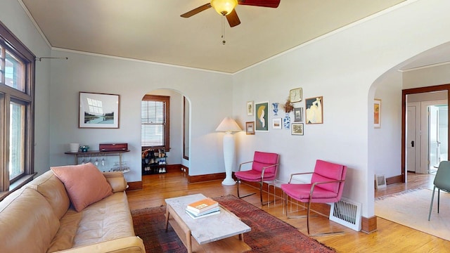 living area with plenty of natural light, arched walkways, wood finished floors, and visible vents