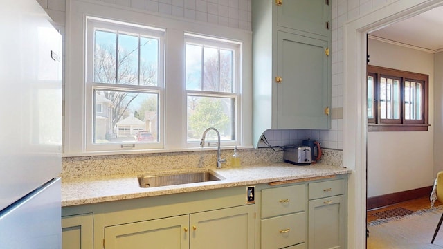 kitchen featuring a sink, plenty of natural light, and freestanding refrigerator