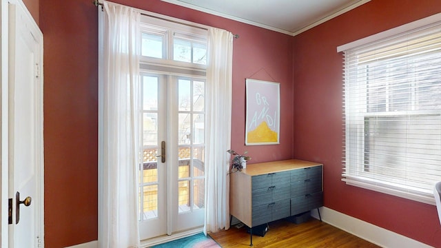 doorway to outside featuring french doors, ornamental molding, baseboards, and wood finished floors