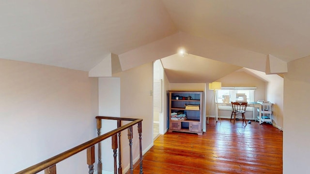 interior space featuring baseboards, vaulted ceiling, and hardwood / wood-style floors