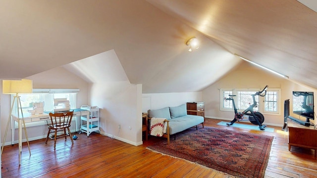 interior space featuring baseboards, lofted ceiling, and hardwood / wood-style floors