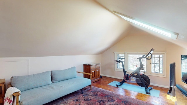 interior space featuring baseboards, wood finished floors, and lofted ceiling