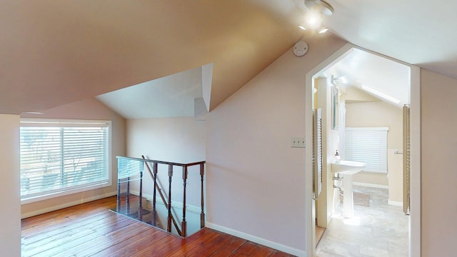 bonus room with baseboards, vaulted ceiling, and hardwood / wood-style flooring