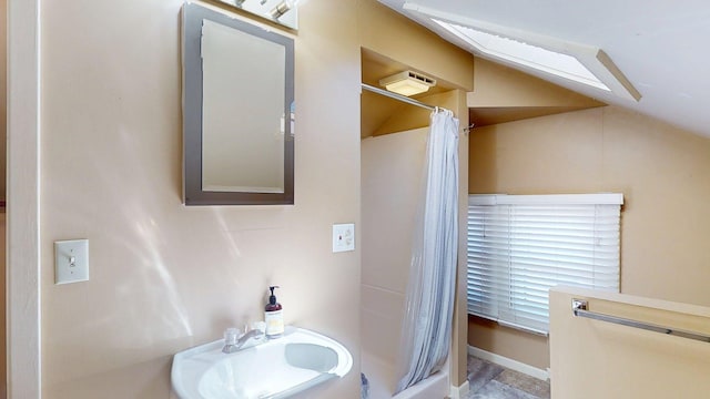 bathroom featuring a sink, vaulted ceiling, and a shower with curtain