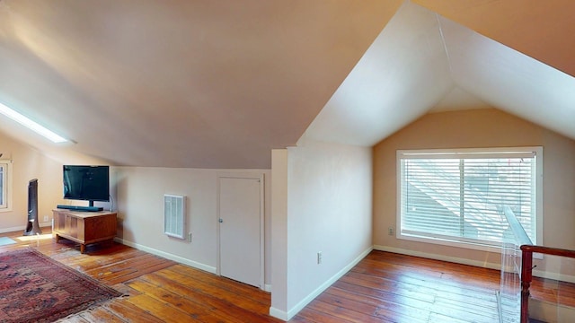bonus room featuring baseboards, wood-type flooring, lofted ceiling, and visible vents