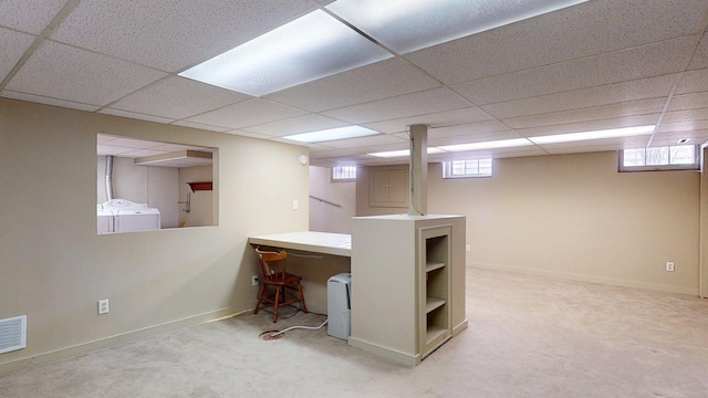 carpeted office space with baseboards, a wealth of natural light, washing machine and dryer, and a paneled ceiling