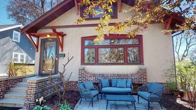exterior space featuring fence, an outdoor hangout area, a patio area, and stucco siding