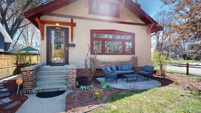 property entrance featuring stucco siding, an outdoor hangout area, and fence