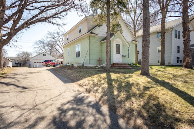1311 Irving St, Alexandria, MN 56308 - view of front of property featuring a detached garage, an outdoor structure, and a front lawn