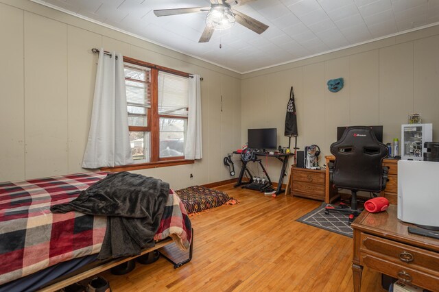 1311 Irving St, Alexandria, MN 56308 - bedroom with crown molding, wood finished floors, a desk, a decorative wall, and ceiling fan