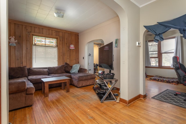 1311 Irving St, Alexandria, MN 56308 - living area featuring arched walkways, ornamental molding, light wood-style flooring, wood walls, and baseboards