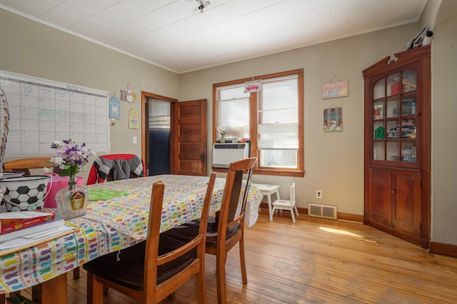 1311 Irving St, Alexandria, MN 56308 - dining space with ornamental molding, cooling unit, light wood-style floors, and baseboards