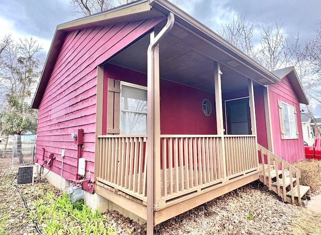 view of side of home featuring fence and central AC