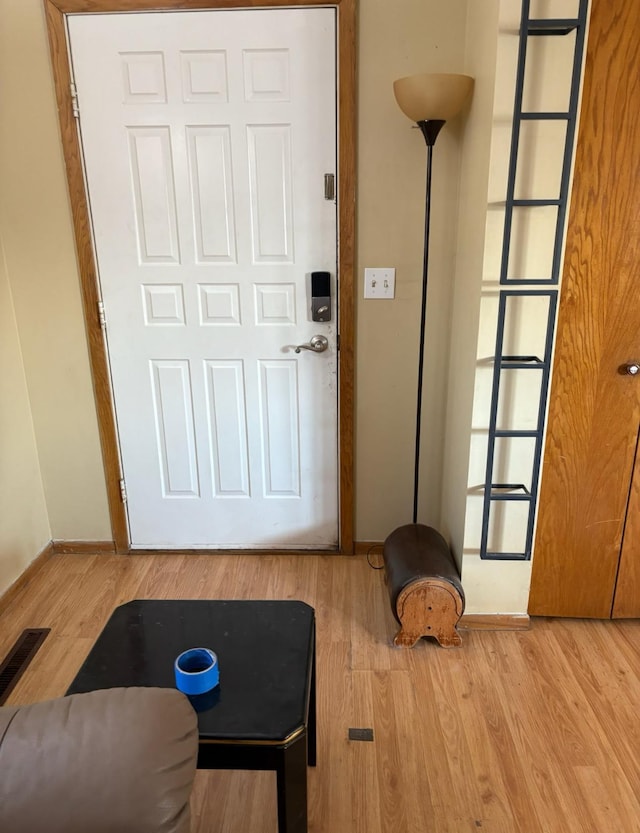 doorway to outside featuring baseboards and light wood-type flooring