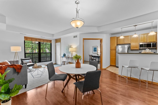2565 Franklin Ave Unit 109, Saint Paul, MN 55114 - dining room featuring light wood-style flooring and a raised ceiling