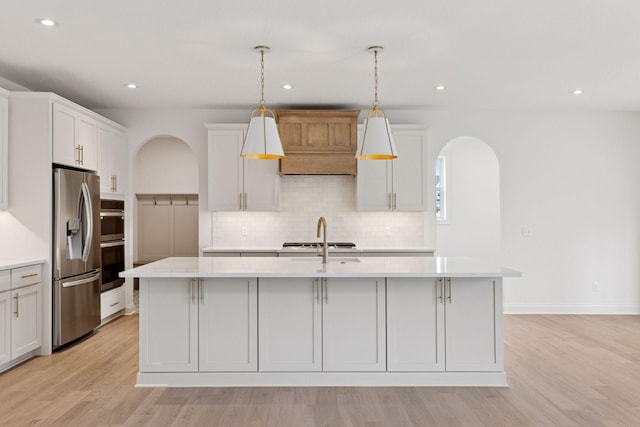 6200 Harkness Alcove S, Cottage Grove, MN 55016 - kitchen featuring stainless steel appliances, arched walkways, light wood-style floors, backsplash, and recessed lighting