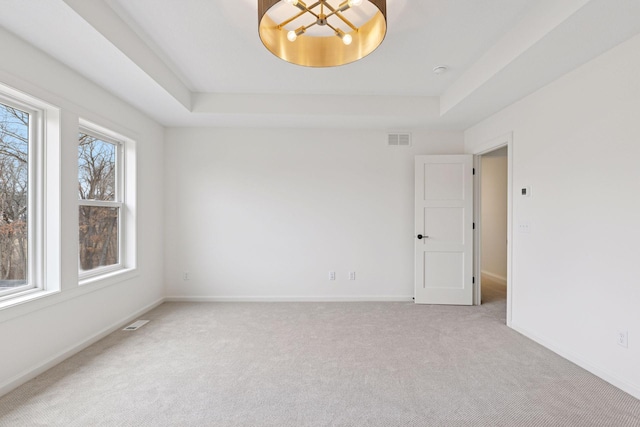 6200 Harkness Alcove S, Cottage Grove, MN 55016 - spare room featuring a tray ceiling, light colored carpet, and a chandelier