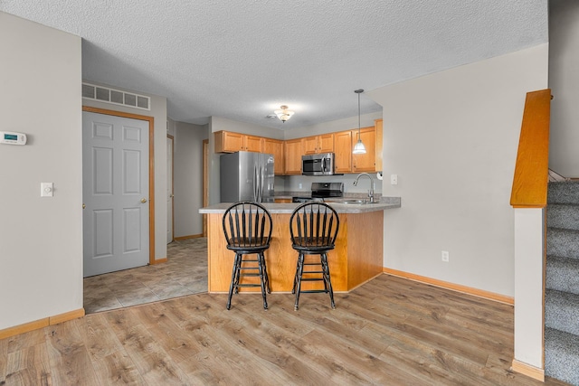 kitchen featuring baseboards, appliances with stainless steel finishes, a sink, and visible vents