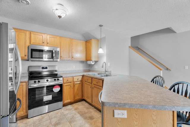 kitchen with a peninsula, a textured ceiling, appliances with stainless steel finishes, and a sink