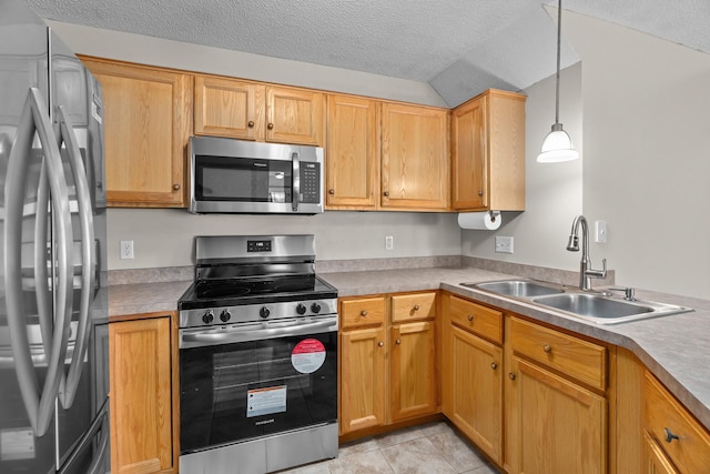 kitchen featuring hanging light fixtures, a textured ceiling, a sink, stainless steel appliances, and light countertops