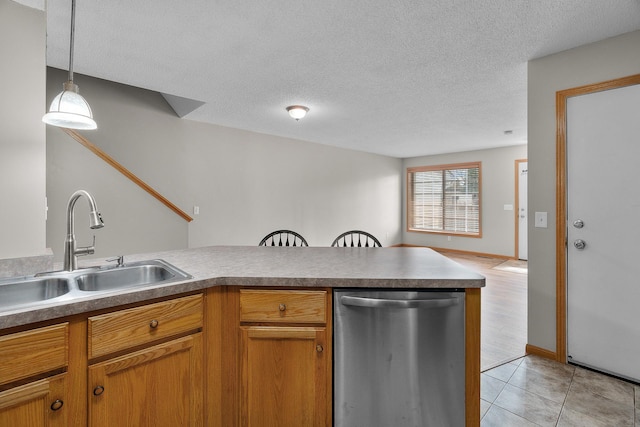 kitchen featuring a peninsula, dishwasher, a sink, and a textured ceiling