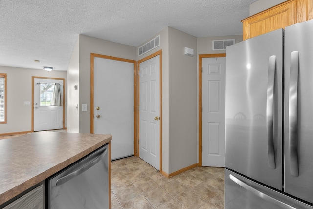 kitchen featuring a textured ceiling, visible vents, and appliances with stainless steel finishes
