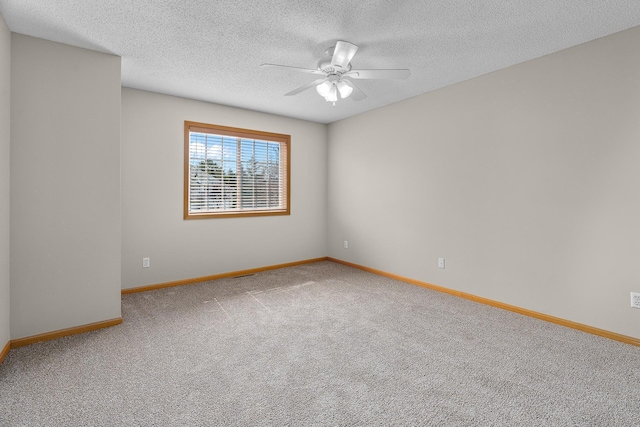 carpeted empty room with a ceiling fan, baseboards, and a textured ceiling