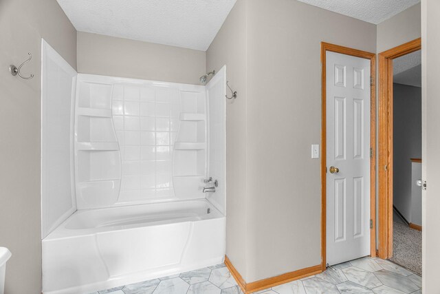 bathroom with shower / bathing tub combination, marble finish floor, and a textured ceiling