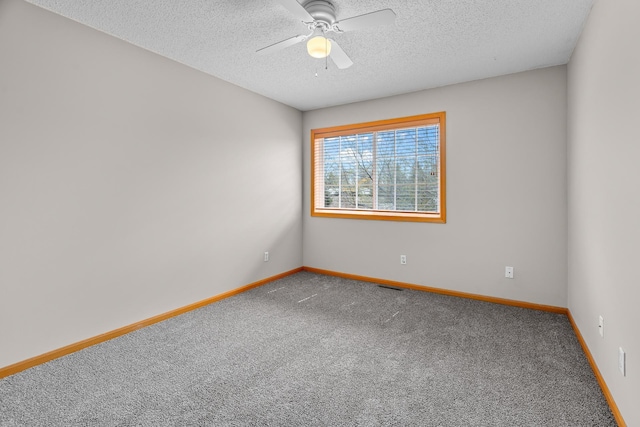 carpeted empty room with a textured ceiling, baseboards, ceiling fan, and visible vents