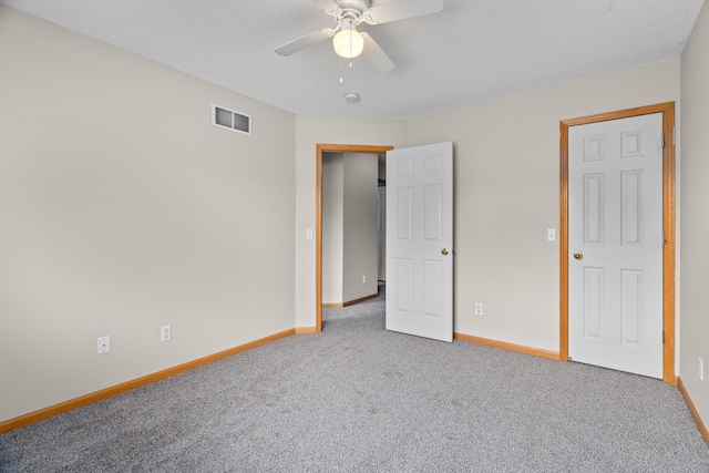 unfurnished bedroom with baseboards, visible vents, carpet floors, and a textured ceiling