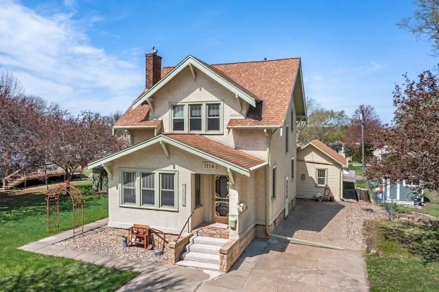 view of front of home with a chimney, a front lawn, concrete driveway, a shingled roof, and stucco siding