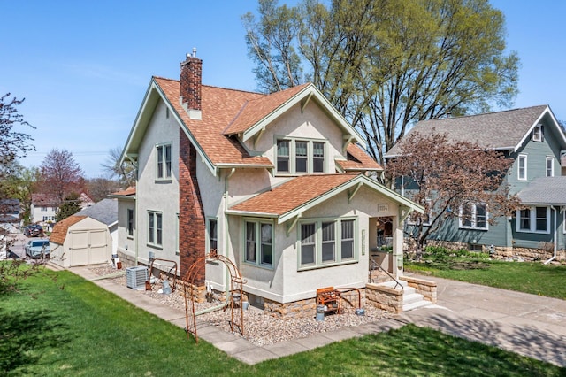 1114 6th St, Mankato, MN 56001 - rear view of property with stucco siding, a chimney, a lawn, central air condition unit, and a shingled roof