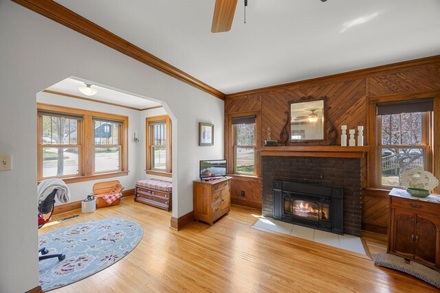 1114 6th St, Mankato, MN 56001 - living room with ornamental molding, plenty of natural light, a brick fireplace, light wood-style floors, and baseboards