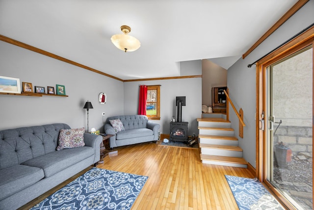 1114 6th St, Mankato, MN 56001 - living room featuring a wood stove, hardwood / wood-style flooring, stairs, crown molding, and baseboards