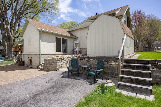 1114 6th St, Mankato, MN 56001 - back of property with roof with shingles, a patio, and stucco siding