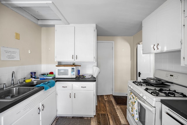 1114 6th St, Mankato, MN 56001 - kitchen featuring white appliances, a sink, dark wood-type flooring, tasteful backsplash, and white cabinetry