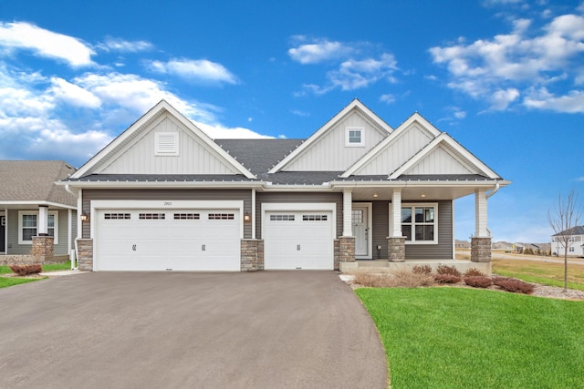 1905 Arbor Ln, Carver, MN 55315 - craftsman-style house with board and batten siding, driveway, a front lawn, a garage, and stone siding