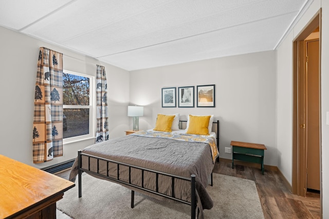 bedroom featuring wood finished floors and baseboards