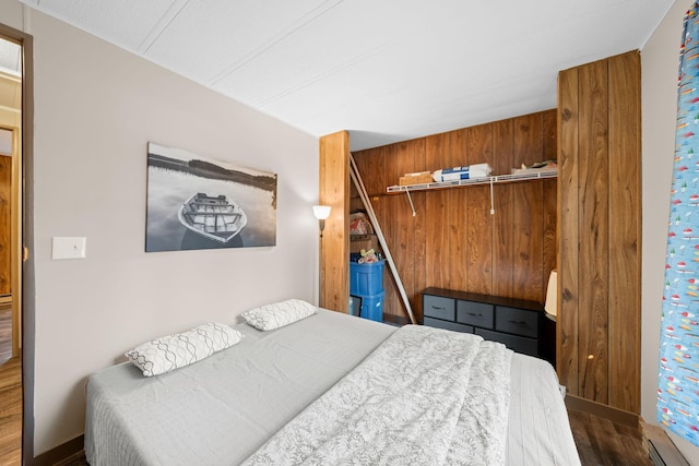 bedroom with wood finished floors, a closet, and baseboards