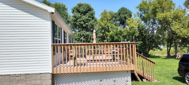 wooden deck featuring a lawn