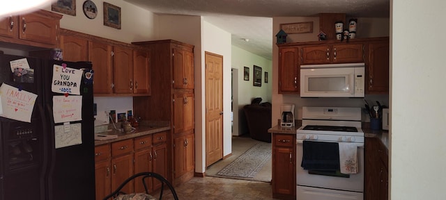 kitchen with brown cabinetry, a textured ceiling, and white appliances