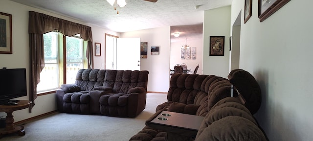 living area featuring plenty of natural light, carpet flooring, a textured ceiling, and ceiling fan