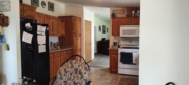 kitchen featuring brown cabinetry, white appliances, and stone finish floor