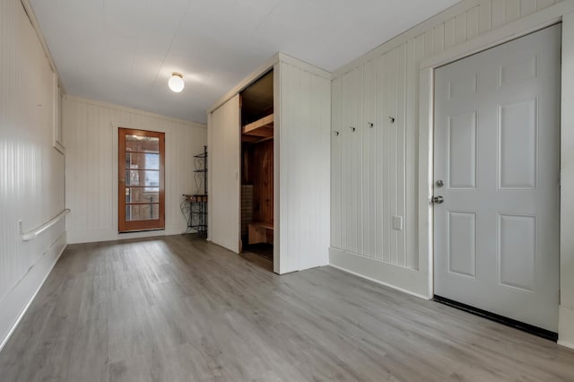 mudroom with wooden walls and light wood-style flooring