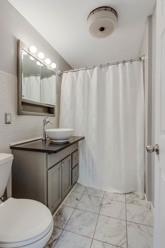 bathroom with marble finish floor, toilet, and vanity